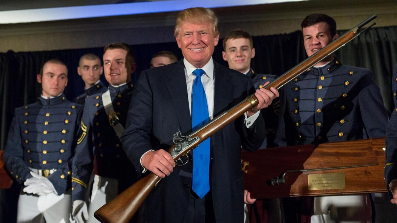 Donald Trump hält in einem Militär College stolz eine Waffe in die Höhe. Donald Trump hält in einem Militär College stolz eine Waffe in die Höhe.