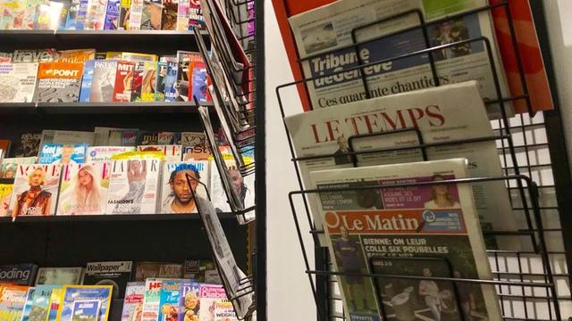 Eine gedruckte Ausgabe der Schweizer Zeitung "Le Matin" hängt neben anderen Zeitungen in einem Kiosk.