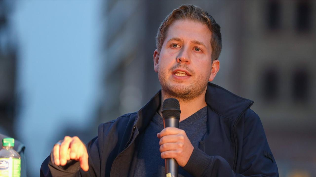 Großaufnahme des SPD-Politikers Kevin Kühnert mit einem Mikrofon in der Hand. Großaufnahme des SPD-Politikers Kevin Kühnert mit einem Mikrofon in der Hand.