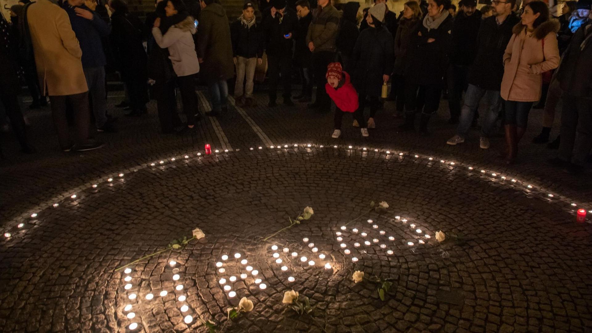 Einen Tag nach der Tat in Hanau: Passanten halten in der Innenstadt mit Kerzen eine Mahnwache für die Opfer ab. Einen Tag nach der Tat in Hanau: Passanten halten in der Innenstadt mit Kerzen eine Mahnwache für die Opfer ab.