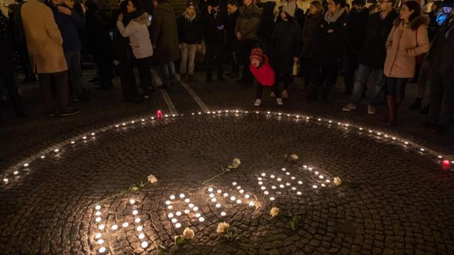 Einen Tag nach der Tat in Hanau: Passanten halten in der Innenstadt mit Kerzen eine Mahnwache für die Opfer ab.