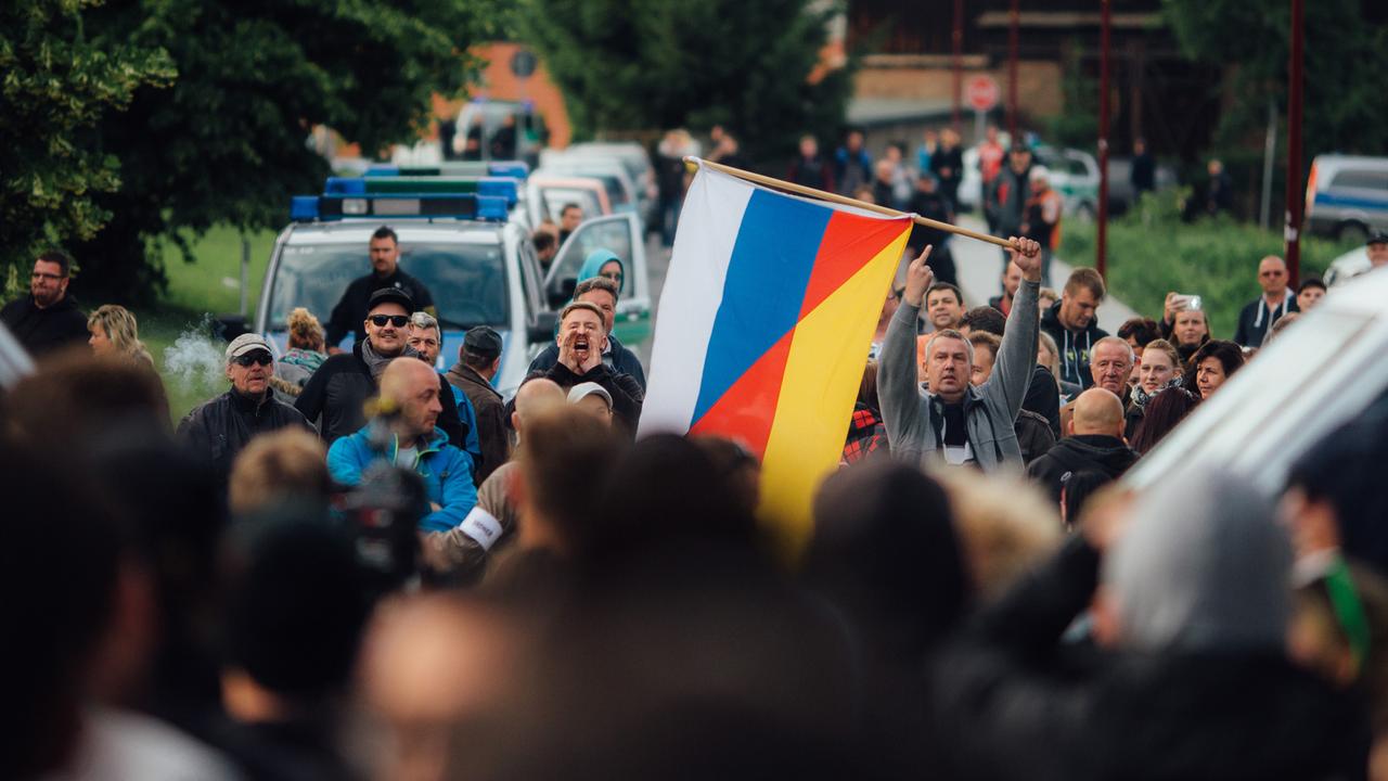 Flüchtlingsgegner protestieren mit einer deutsch-russischen Fahne am 24.06.2015 vor einer Unterkunft von Asylbewerbern (Leonardo-Hotel) in Freital (Sachsen). Flüchtlingsgegner protestieren mit einer deutsch-russischen Fahne am 24.06.2015 vor einer Unterkunft von Asylbewerbern (Leonardo-Hotel) in Freital (Sachsen).