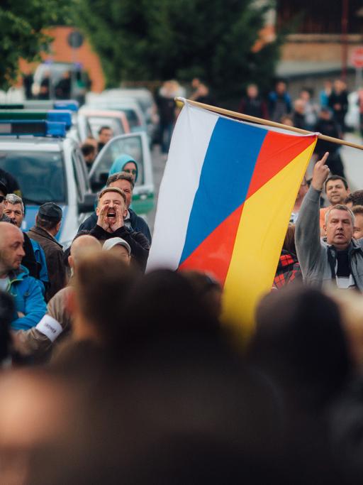 Flüchtlingsgegner protestieren mit einer deutsch-russischen Fahne am 24.06.2015 vor einer Unterkunft von Asylbewerbern (Leonardo-Hotel) in Freital (Sachsen).
