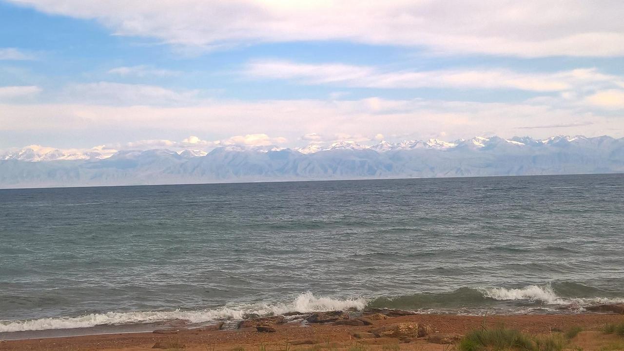 Der zweithöchstgelegene Bergsee der Welt: Issyk Kul im Norden Kirgistans sieht aus wie ein Meer mit Bergen im Hintergrund.