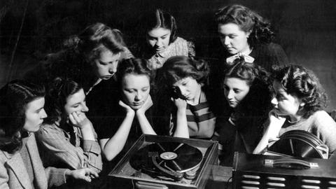 Frauen hören in der Canning Town Bücherei in Pretoria auf einem Grammophon Musik (1947).