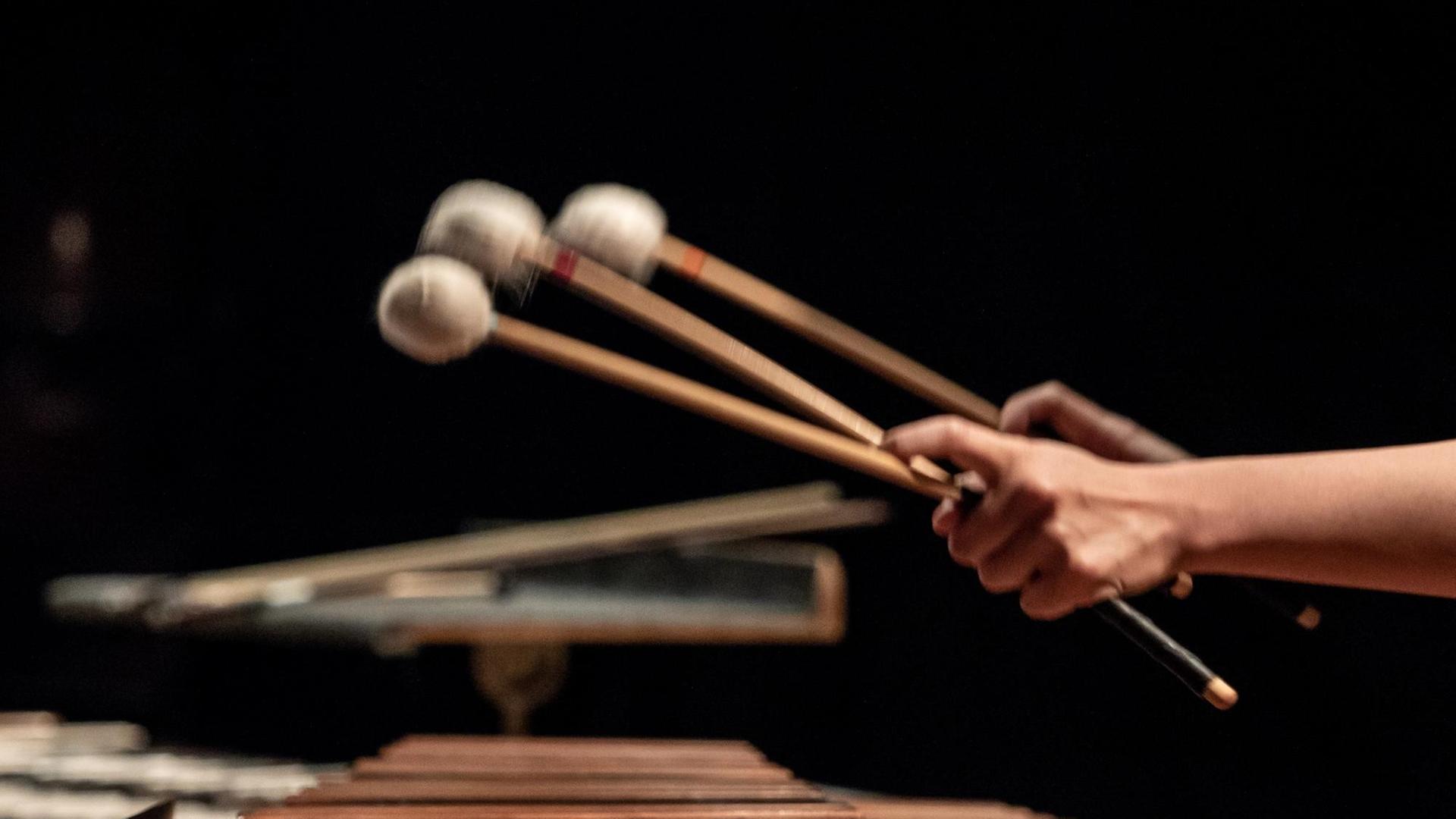 Hände mit Schlägeln trommeln auf einer Marimba. Hände mit Schlägeln trommeln auf einer Marimba.