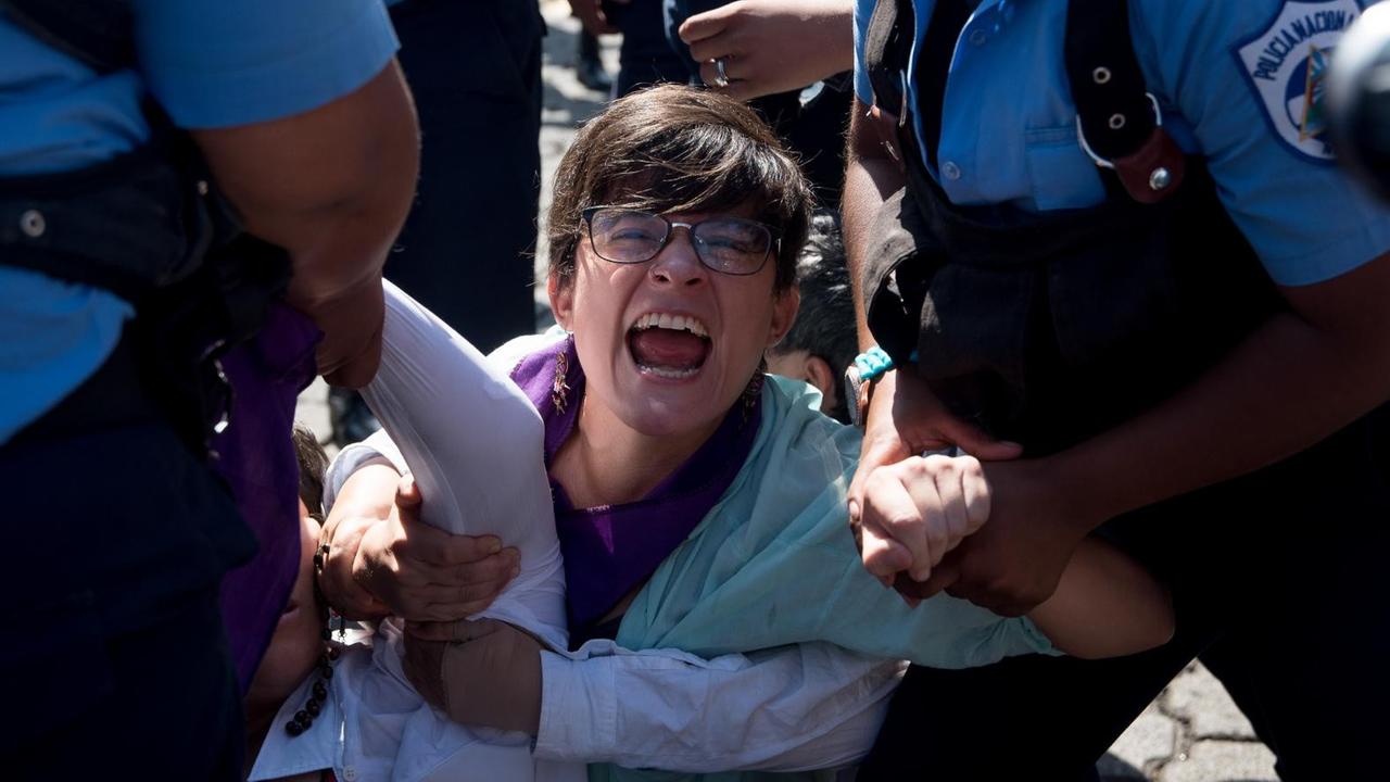 Polizisten verhaften eine Frau bei einer Demonstration gegen die Regierung