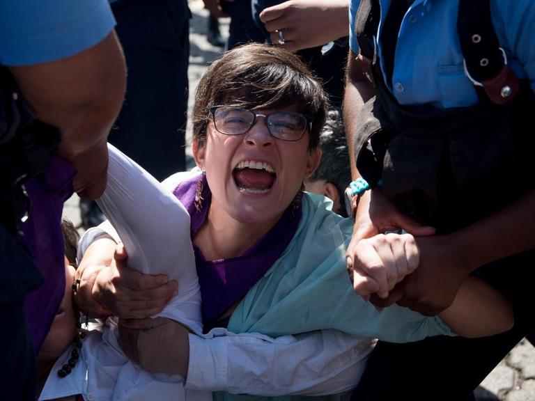 Polizisten verhaften eine Frau bei einer Demonstration gegen die Regierung