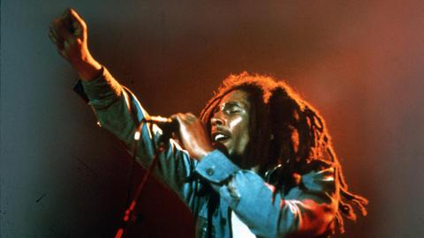 Bob Marley bei einem Konzert am Mikrofon.