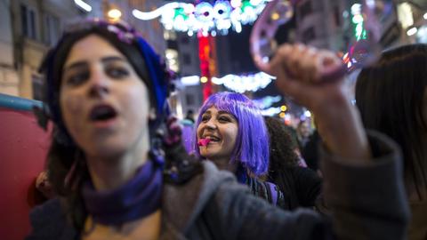 Frauen mit erhobener Fraust und lila Haaren demonstrieren in der Istiklal Avenue am Internationalen Frauentag am 8. März 2017 im Bezirk Beyoglu in Istanbul in der Türkei