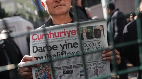 Ein Mann demonstriert mit einer Ausgabe der "Cumhuriyet" gegen die Festnahmen von türkischen Journalisten.
