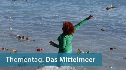 Eine Frau wirft in Nizza Blumen für im Mittelmeer gestorbene Migranten ins Meer, Aufnahme vom April 2015