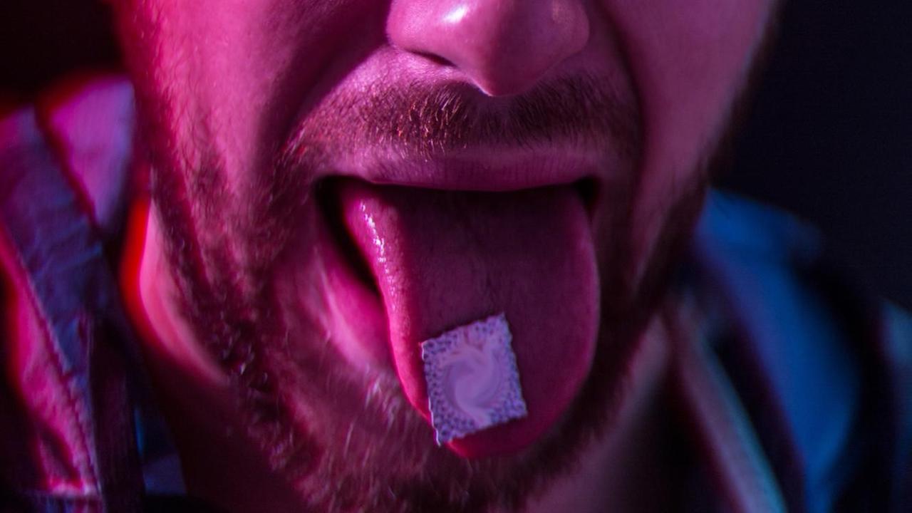LSD auf der Zunge eines Mannes. LSD auf der Zunge eines Mannes.