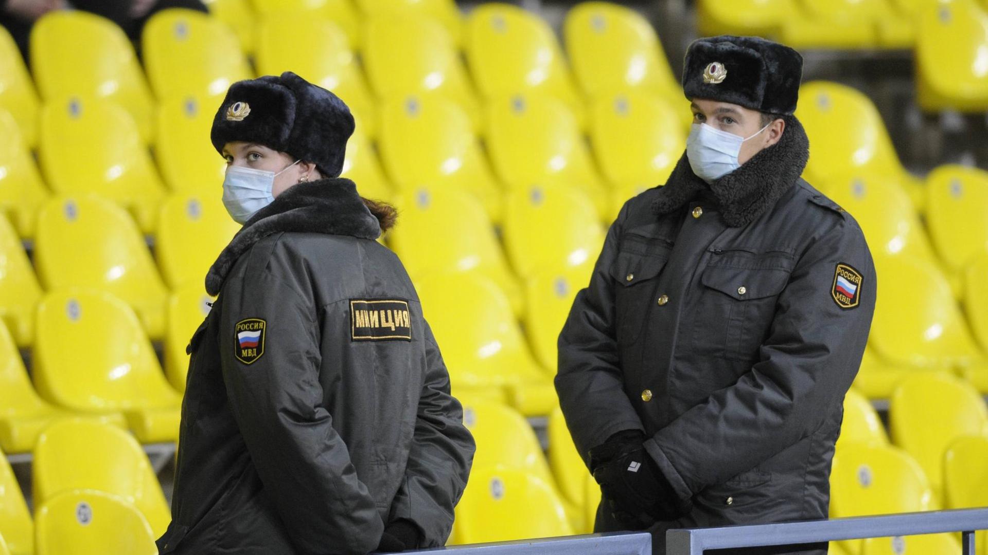 Sicherheitskräfte mit Mundschutz bei einem Fußballspiel in Moskau Sicherheitskräfte mit Mundschutz bei einem Fußballspiel in Moskau
