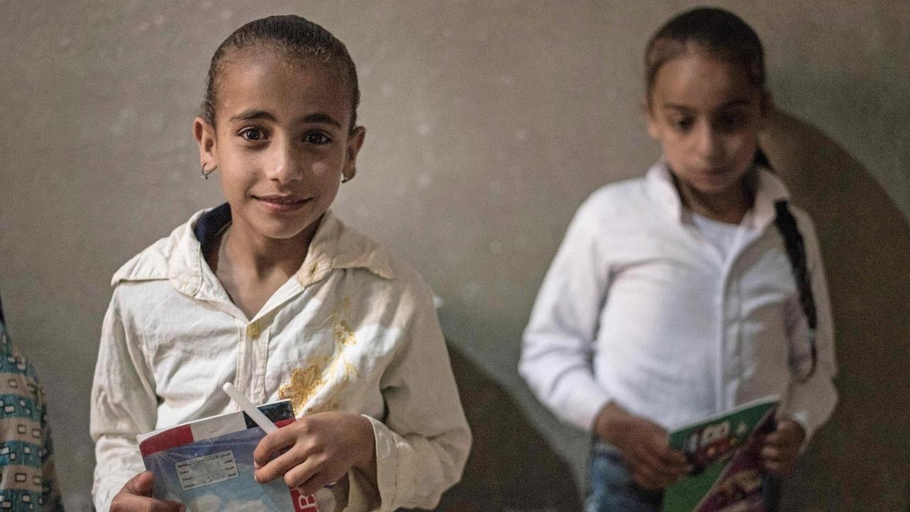 Zwei Mädchen aus dem koptischen Dorf Al-Barsha in Oberägypten, mit Schulheften in den Händen. Zwei Mädchen aus dem koptischen Dorf Al-Barsha in Oberägypten, mit Schulheften in den Händen.