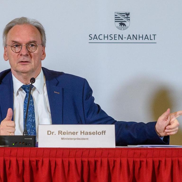 Reiner Haseloff (CDU), Ministerpräsident des Landes Sachsen-Anhalt, an einem Tisch bei einer Pressekonferenz