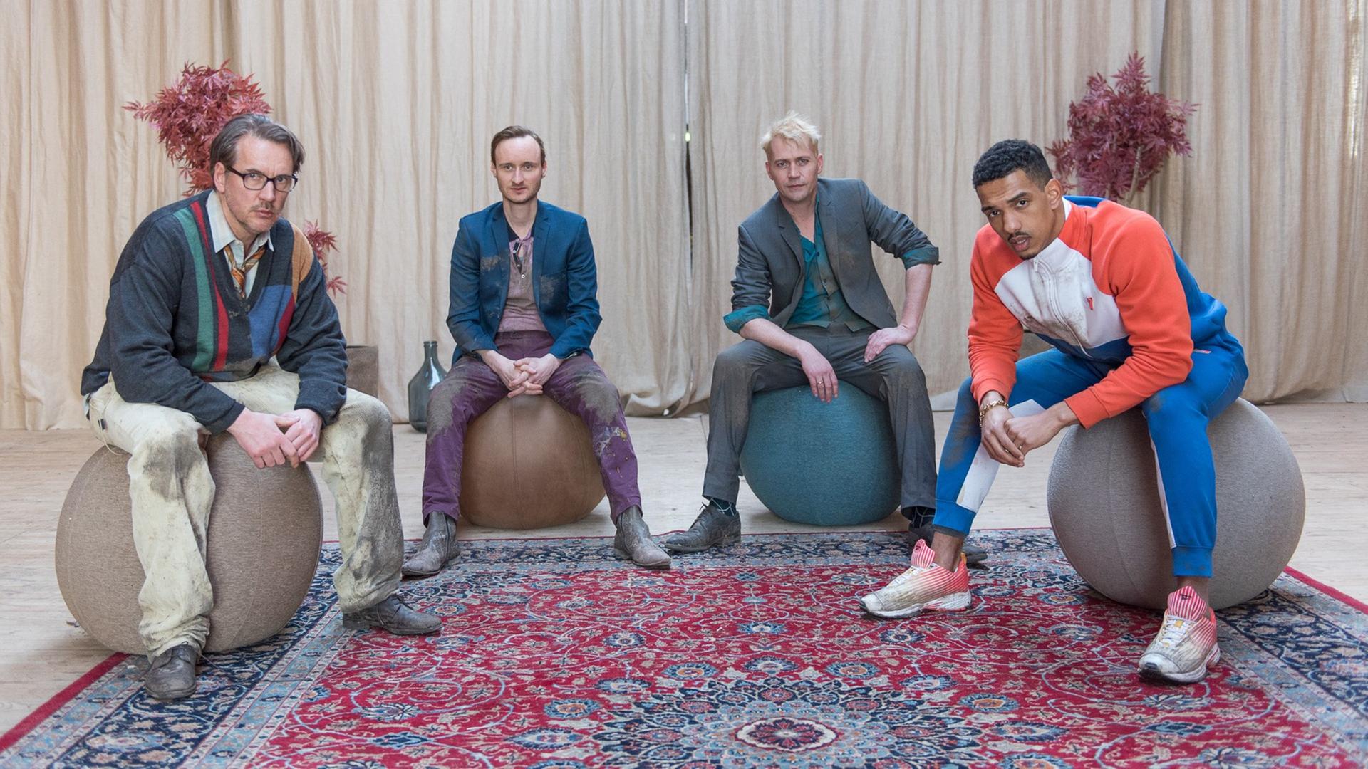 #heuldoch - Therapie wie noch nie: Die Männer-Therapiegruppe: Ferdinand (Steffen C. Jürgens, l.), Julian (Sebastian Brandes, 2. v. l.), Ralf (Nikolaus Kühn, 2. v. r.) und Kobe (Karim Ben Mansur, r.) sitzen auf großen Gymnastikbällen auf einem Orientteppich in einem Halbkreis und blicken in die Kamera. #heuldoch - Therapie wie noch nie: Die Männer-Therapiegruppe: Ferdinand (Steffen C. Jürgens, l.), Julian (Sebastian Brandes, 2. v. l.), Ralf (Nikolaus Kühn, 2. v. r.) und Kobe (Karim Ben Mansur, r.) sitzen auf großen Gymnastikbällen auf einem Orientteppich in einem Halbkreis und blicken in die Kamera.