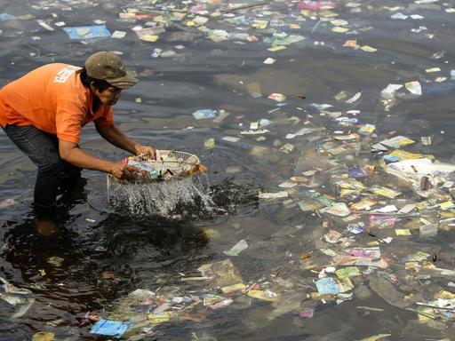 Ein Müllsammler fischt Plastiktüten aus der Bucht von Manila. Anlass war der 5. internationale plastikfreie Tag.