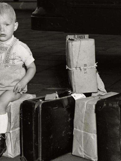 Symbolbild Kinderverschickung. Verschickung von Flüchtlingskindern aus Berlin zu einem Ferienaufenthalt nach Westdeutschland. Ein kleiner Junge wartet auf dem Flugfeld des Flughafens Tempelhof, 17. August 1953.