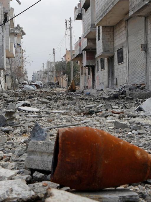 Eine Mörsergranate liegt in einer Straße in Kobane zwischen den Trümmern.
