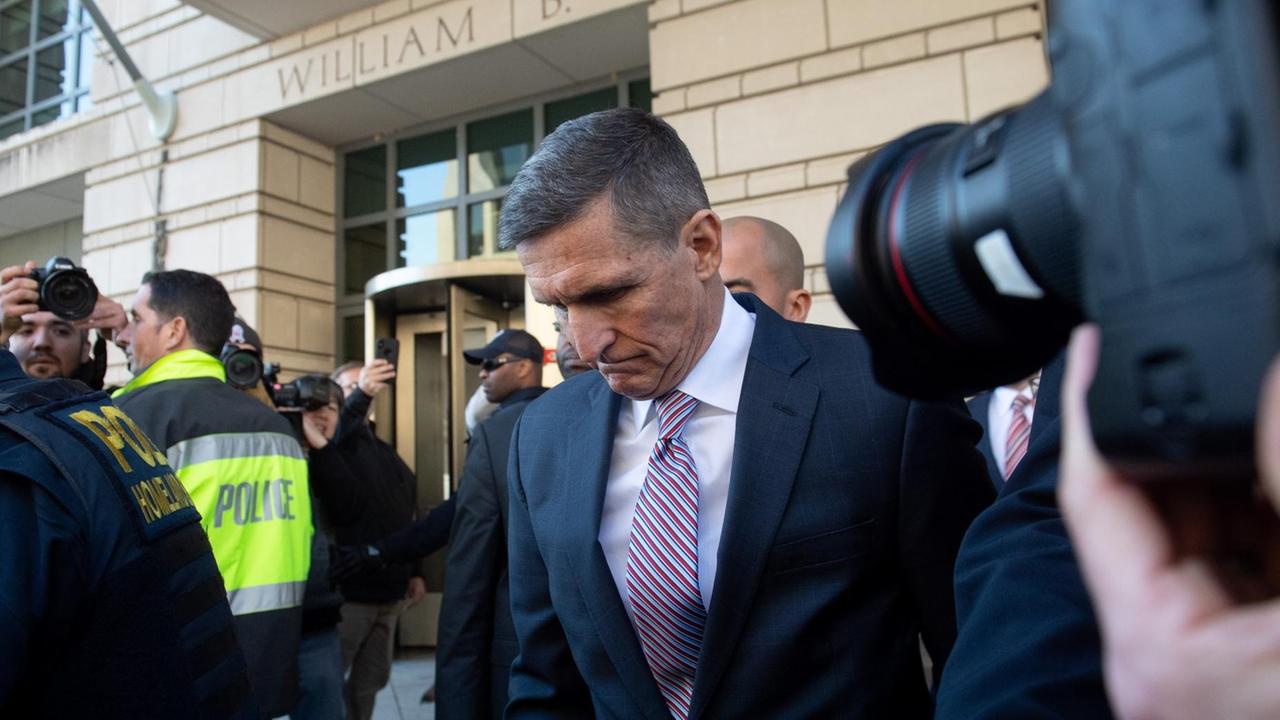 Der ehemalige Nationale Sicherheitsberater der USA, Michael Flynn, verlässt mit geneigtem Kopf ein Bundesregricht in Washington D.C. Er wird von Polizisten begleittet und mehrere Fotografen machen Fotos. Der ehemalige Nationale Sicherheitsberater der USA, Michael Flynn, verlässt mit geneigtem Kopf ein Bundesregricht in Washington D.C. Er wird von Polizisten begleittet und mehrere Fotografen machen Fotos.