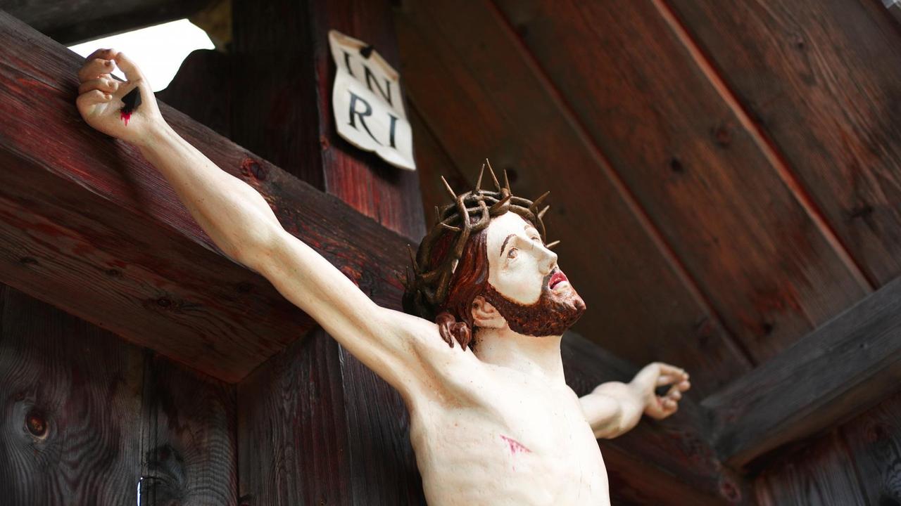 Eine Jesusfigur an einem Wegkreuz in Tirol, Österreich Eine Jesusfigur an einem Wegkreuz in Tirol, Österreich