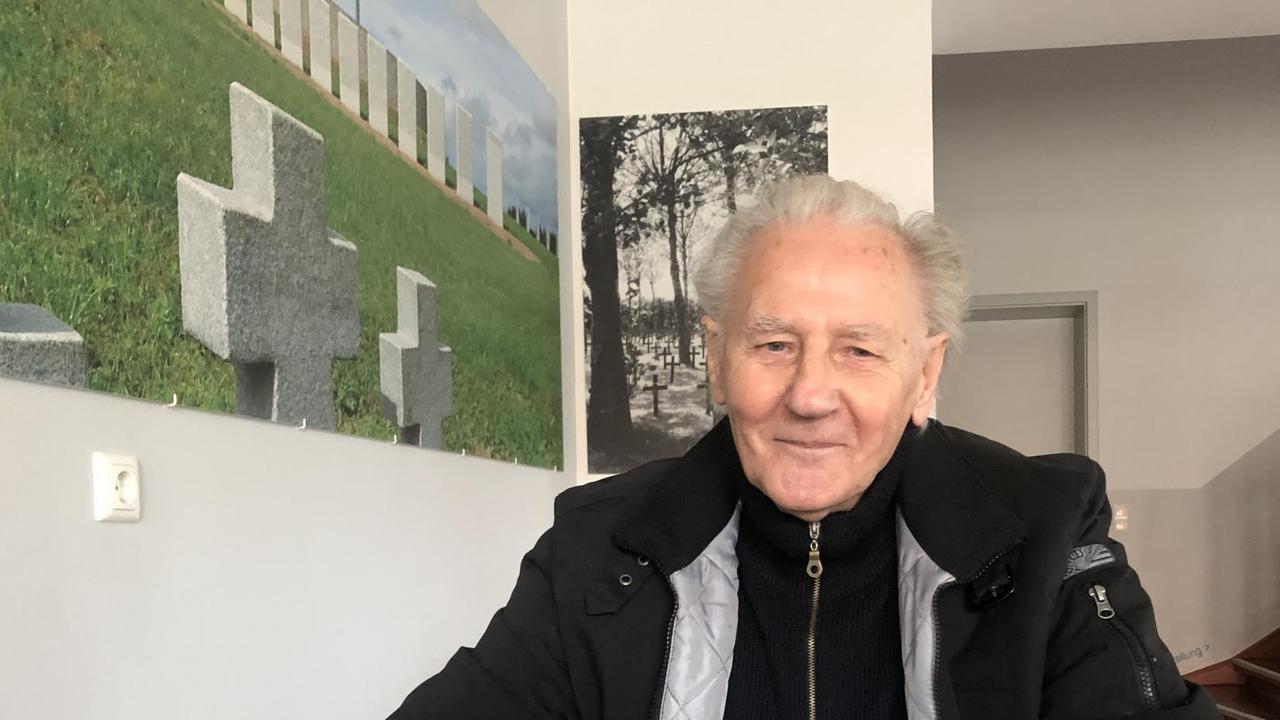 Willi Lehmann mit einer Brille in der Hand an einem Tisch sitzend und in die Kamera lächelnd Willi Lehmann mit einer Brille in der Hand an einem Tisch sitzend und in die Kamera lächelnd