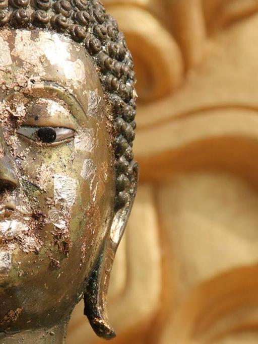 Beschädigte Buddha-Figur in einem Tempel.