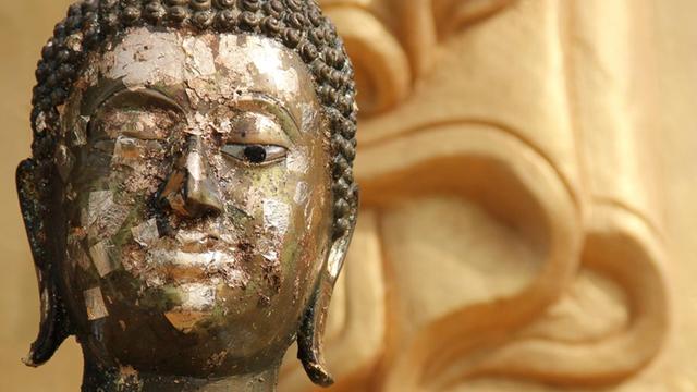 Beschädigte Buddha-Figur in einem Tempel.