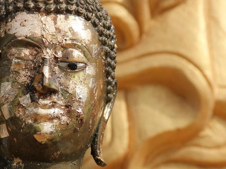 Beschädigte Buddha-Figur in einem Tempel.