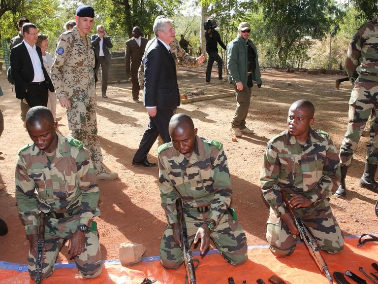 Bundespräsident Joachim Gauck geht im Feldlager Koulikoro in Mali, im Camp Gecko, an malischen Soldaten vorbei, die an Waffen ausgebildet werden.