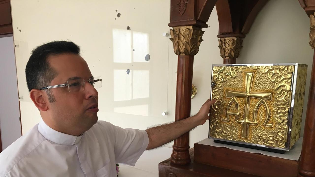 Pater Raul zeigt die Einschüsse im Tabernakel der Kirche Kirche La Divina Misericordia, Nicaragua Pater Raul zeigt die Einschüsse im Tabernakel der Kirche Kirche La Divina Misericordia, Nicaragua