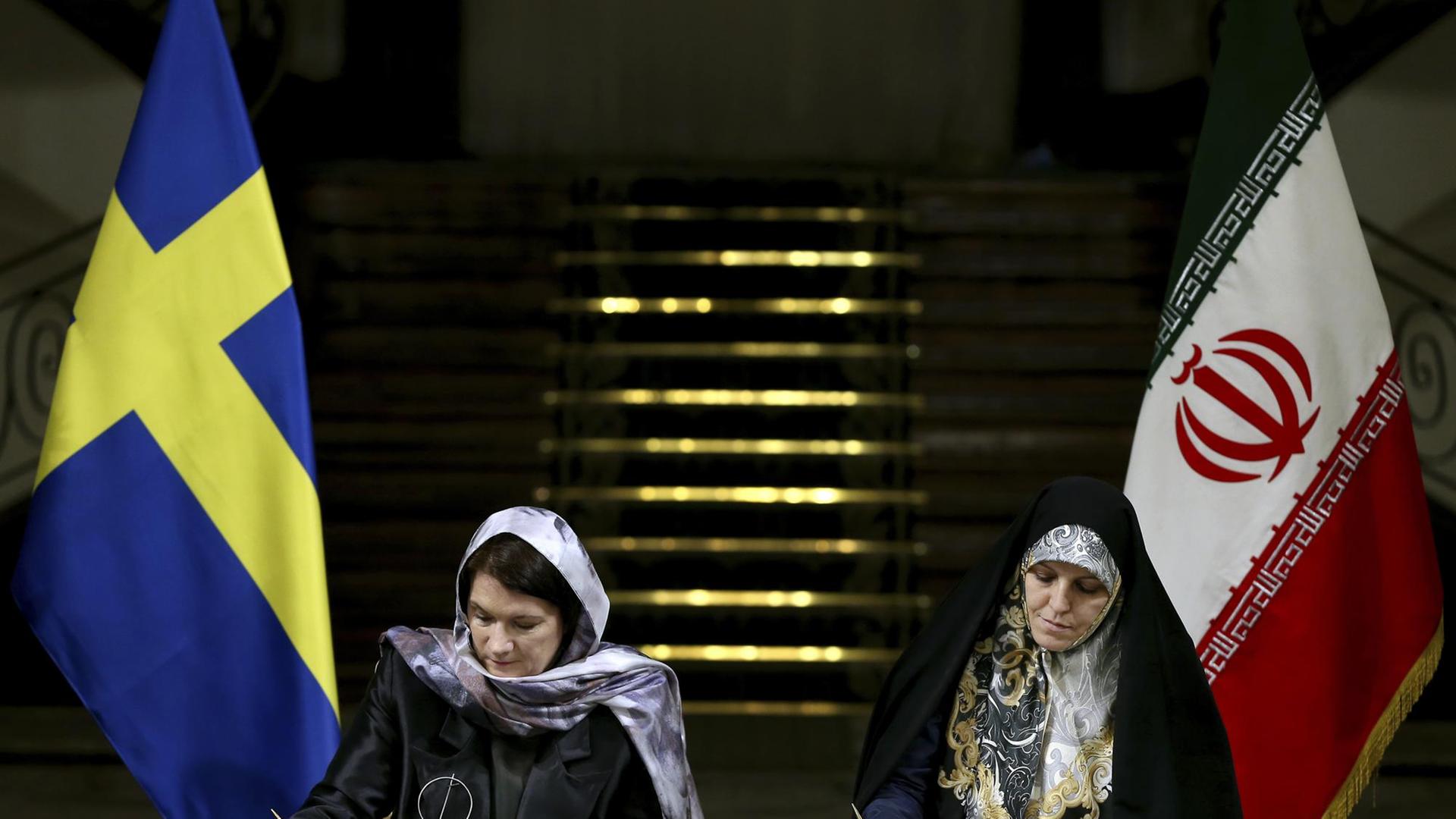 Die schwedische Handelsministerin Ann Linde und Irans Vizepräsidentin für Frauen- und Familienangelegenheiten, Shahindokht Molaverdi, unterzeichnen ein Abkommen in Teheran. Die schwedische Handelsministerin Ann Linde und Irans Vizepräsidentin für Frauen- und Familienangelegenheiten, Shahindokht Molaverdi, unterzeichnen ein Abkommen in Teheran.
