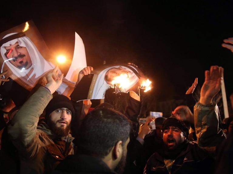 Iranische Demonstranten verbrennen Fotos der königlichen Familie Saudi-Arabiens vor derern Botschaft in Teheran, Iran, nachdem zuvor unter anderem ein schiitischer Geistlicher dort hingerichtet worden war.