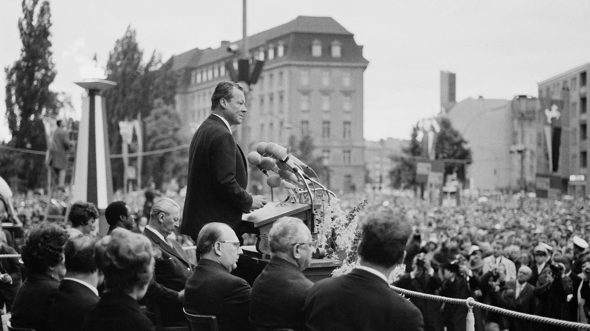 Schwarzweiß-Aufnahme des SPD-Politikers und Regierenden Bürgermeisters von Berlin, Willy Brandt, während seiner Rede zum Tag der Deutschen Einheit am 17. Juni 1965 vor dem Rathaus Schöneberg. Schwarzweiß-Aufnahme des SPD-Politikers und Regierenden Bürgermeisters von Berlin, Willy Brandt, während seiner Rede zum Tag der Deutschen Einheit am 17. Juni 1965 vor dem Rathaus Schöneberg.