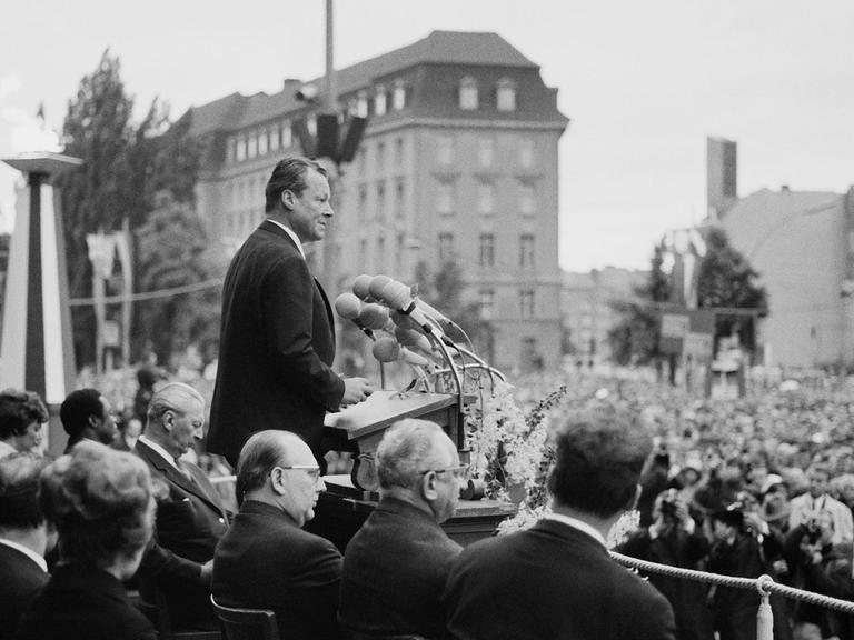 Schwarzweiß-Aufnahme des SPD-Politikers und Regierenden Bürgermeisters von Berlin, Willy Brandt, während seiner Rede zum Tag der Deutschen Einheit am 17. Juni 1965 vor dem Rathaus Schöneberg.