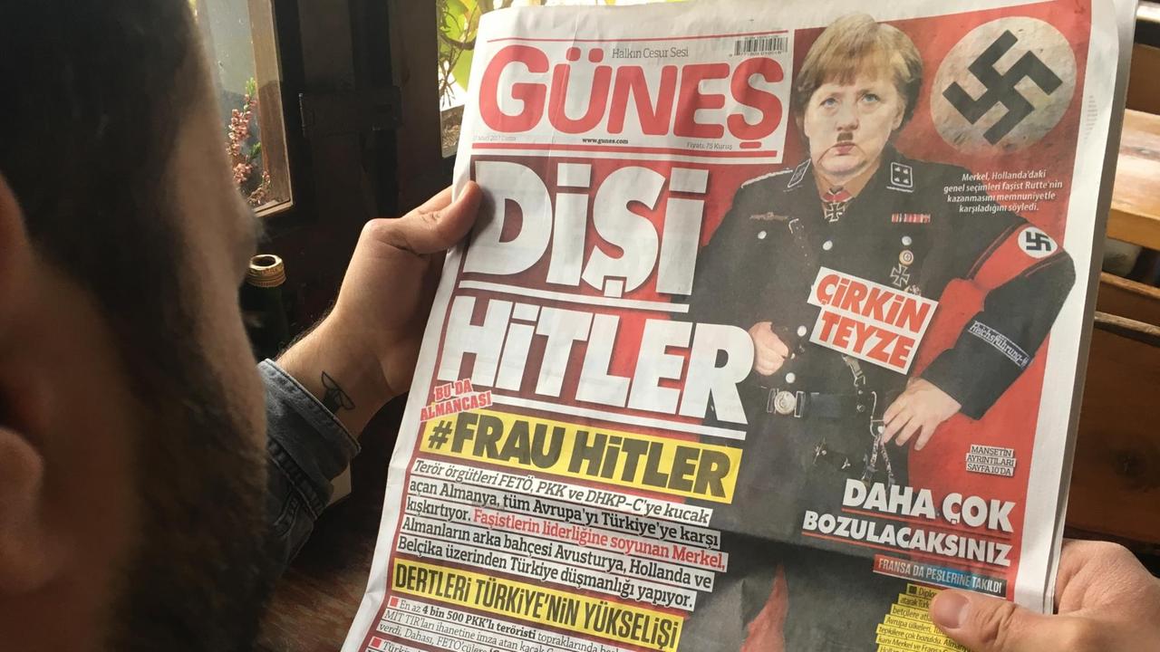 Ein Mann liest am 17.03.2017 in Istanbul die Ausgabe der türkischen Tageszeitung "Günes" vom gleichen Tag, auf der Bundeskanzlerin Merkel mit SS-Uniform, Hakenkreuz und Hitlerbart zu sehen ist. Auf der Titelseite wird Merkel als "Frau Hitler" und "hässliche Tante" verunglimpft.