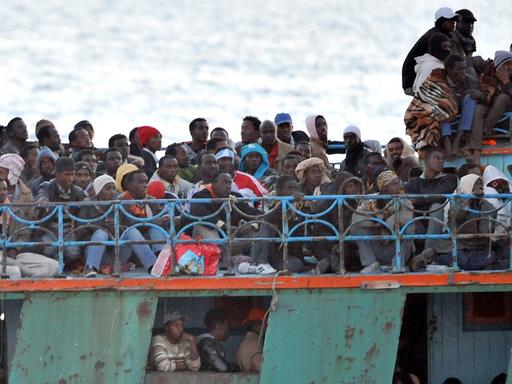 Ein überfülltes Boot mit Flüchtlingen aus Afrika schwimmt vor der italienischen Insel Lampedusa.