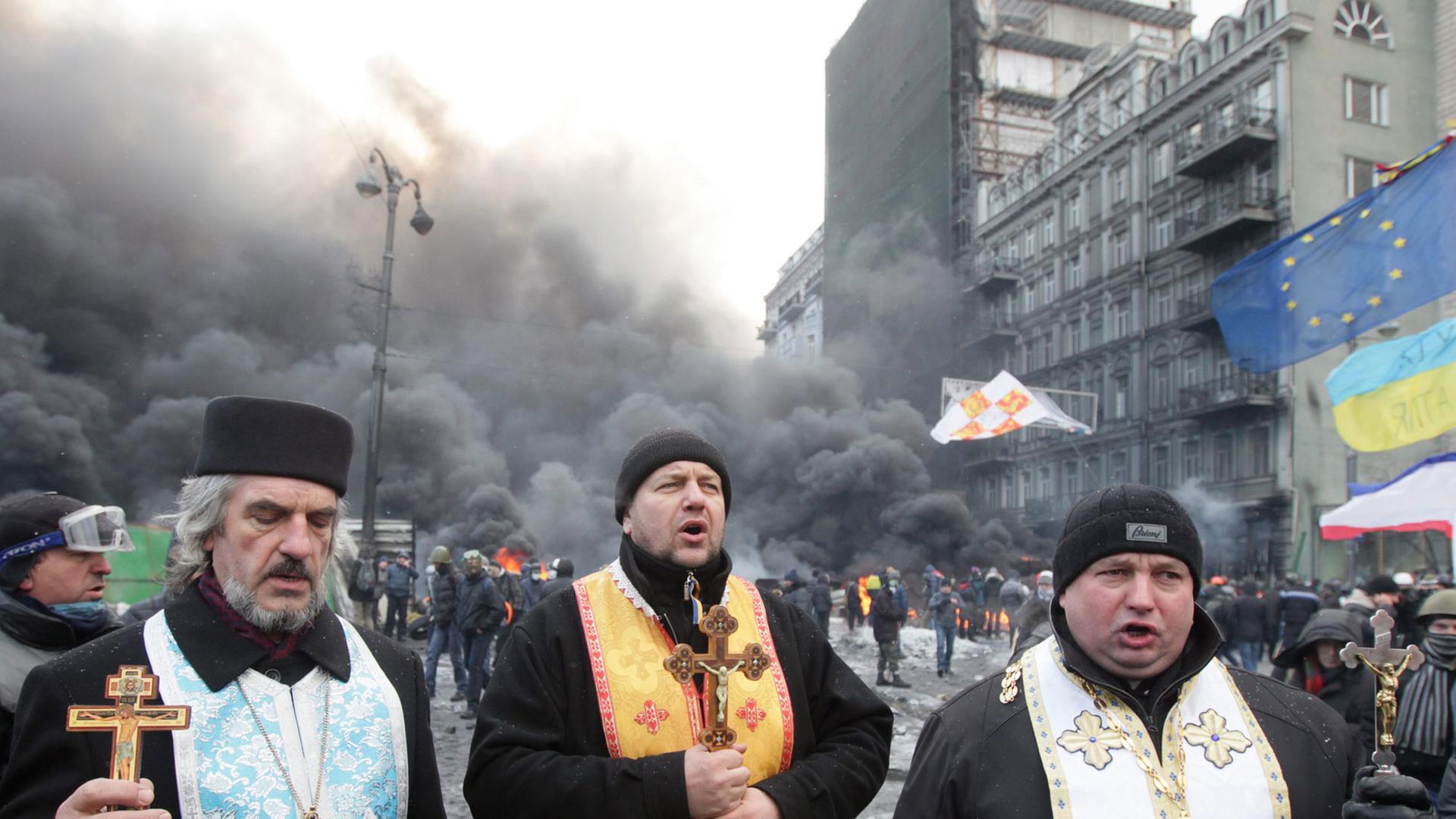 Orthodoxe Priester beten während eines Protests in Kiew. Orthodoxe Priester beten während eines Protests in Kiew.