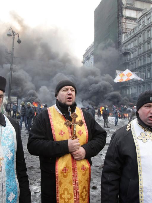 Orthodoxe Priester beten während eines Protests in Kiew.