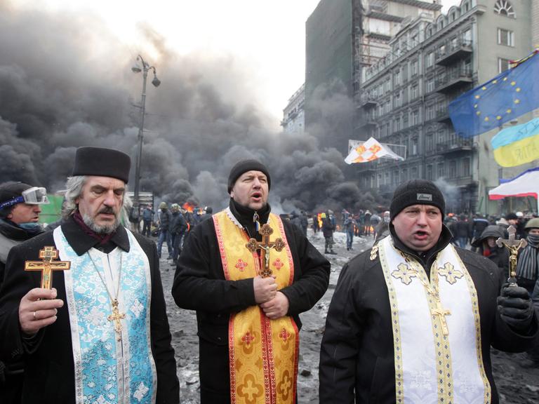 Orthodoxe Priester beten während eines Protests in Kiew.