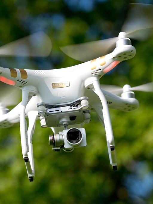 Eine ferngesteuerte Drohne mit einer Kamera schwebt in der Luft.
