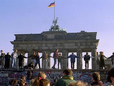 Am 10.11.1989 tanzen Menschen auf der Mauer vor dem Brandenburger Tor