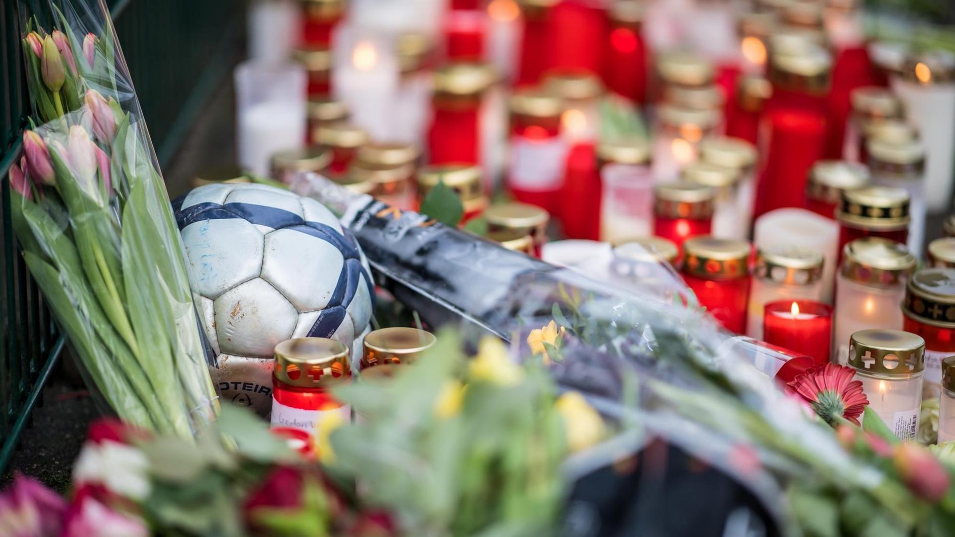An der Käthe-Kollwitz-Gesamtschule in Lünen (Nordrhein-Westfalen) liegt am 24.01.2018 zwischen Trauerkerzen und Blumen ein Fußball. Ein Schüler soll einen Mitschüler getötet haben. Der tatverdächtige 15-Jährige wurde am Dienstagmorgen festgenommen, wie Staatsanwaltschaft und Polizei in Dortmund mitteilten.
