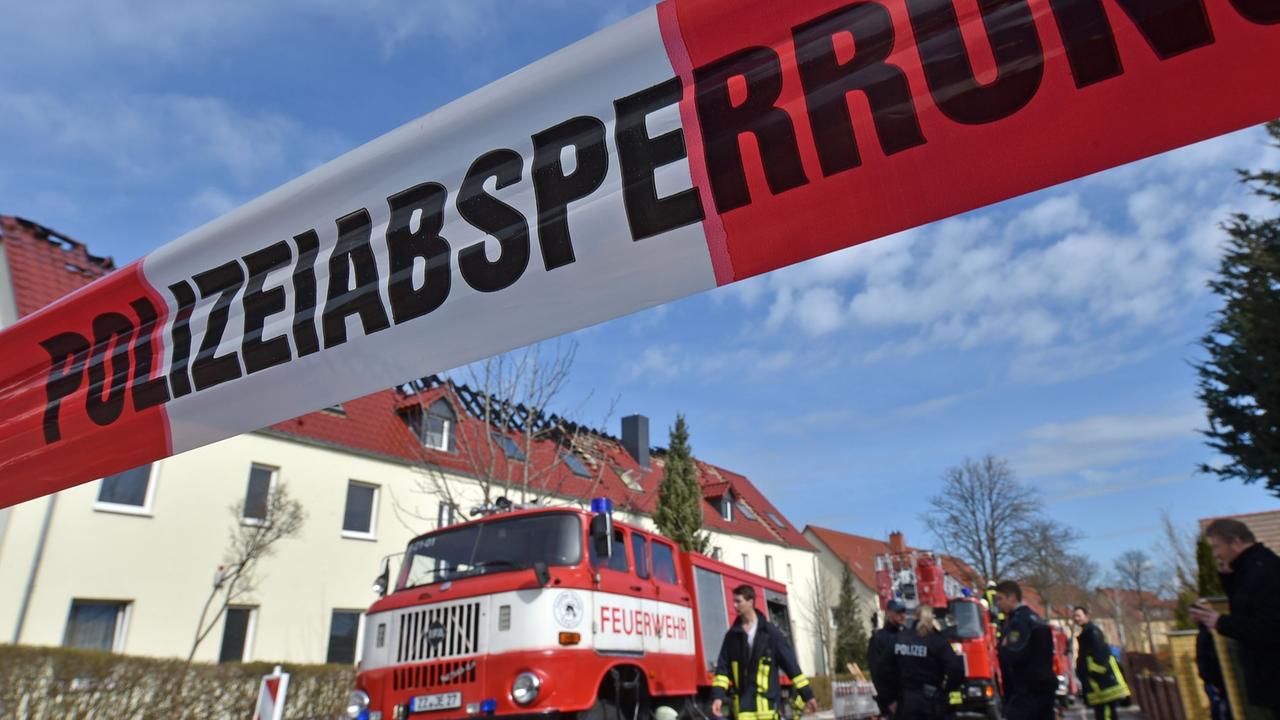 Einsatzkräfte von Feuerwehr und Polizei stehen am 04.04.2015 vor der zukünftigen Unterkunft für Asylbewerber in Tröglitz (Sachsen-Anhalt). In der Nacht hatte es in dem Gebäude gebrannt. Die Polizei ermittelt wegen Verdacht auf Brandstiftung. Einsatzkräfte von Feuerwehr und Polizei stehen am 04.04.2015 vor der zukünftigen Unterkunft für Asylbewerber in Tröglitz (Sachsen-Anhalt). In der Nacht hatte es in dem Gebäude gebrannt. Die Polizei ermittelt wegen Verdacht auf Brandstiftung.
