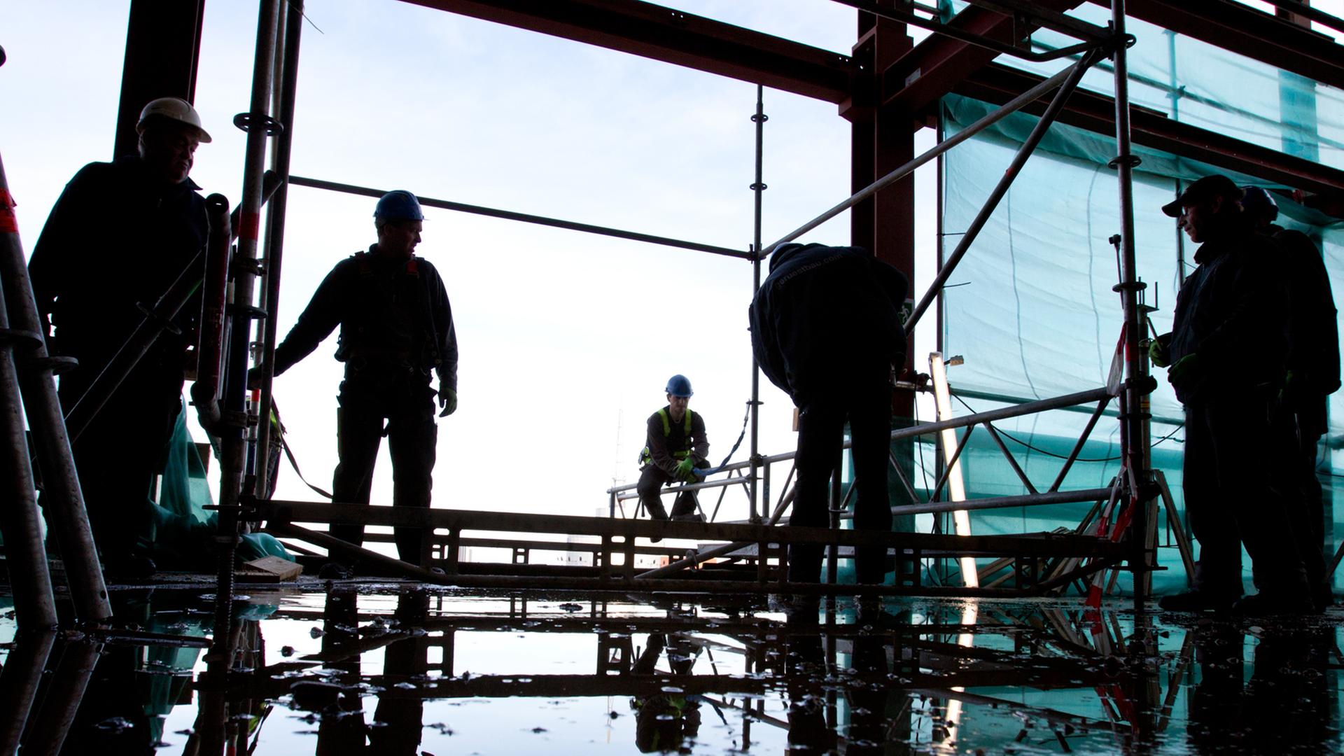 Gerüstbauer arbeiten auf einer Baustelle. Gerüstbauer arbeiten auf einer Baustelle.