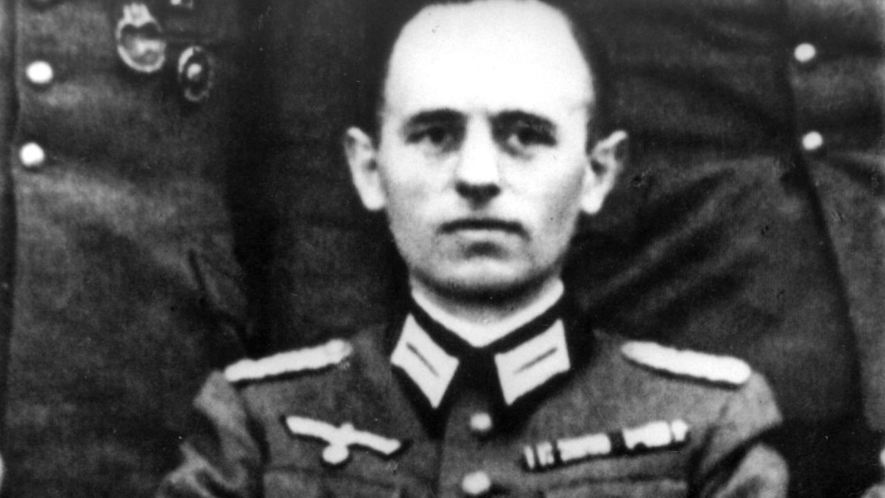 Reinhard Gehlen trägt auf einen Schwarz-Weiß-Foto eine Uniform. Reinhard Gehlen trägt auf einen Schwarz-Weiß-Foto eine Uniform.