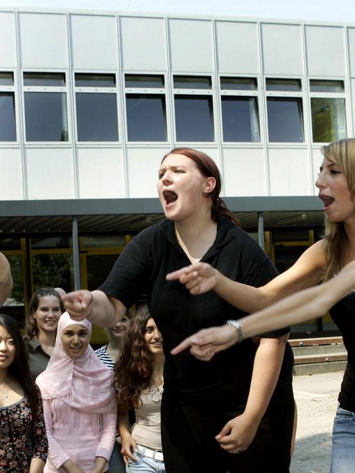 Schülerinnen der Liebig-Schule in Frankfurt am Main beschimpfen in einer gespielten Szene lautstark einen "Agressor" (l).