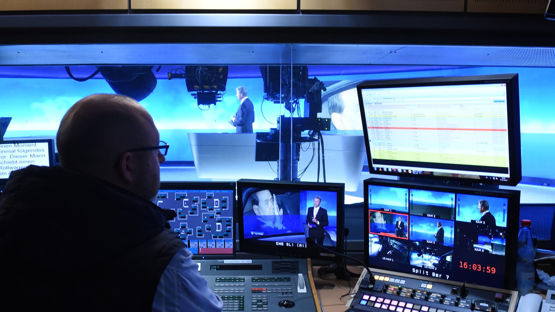 Ein Redakteur sitzt im Regieraum der ARD-Tagesschau vor eine Reihe Fernseh- und Computermonitoren. Ein Redakteur sitzt im Regieraum der ARD-Tagesschau vor eine Reihe Fernseh- und Computermonitoren.