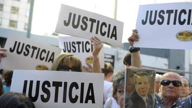 Menschen in Buenos Aires halten Plakate hoch - aus Protest gegen den mysteriösen Tod eines Staatsanwalts, der im Fall des Anschlags auf das jüdische Gemeindezentrum Amia 1994 mit 85 Toten ermittelte.
